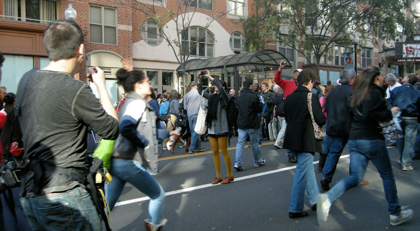 Rally attendants leaving by foot while some stop to take photos of the retreating crowd. Photo by Haoyan of America